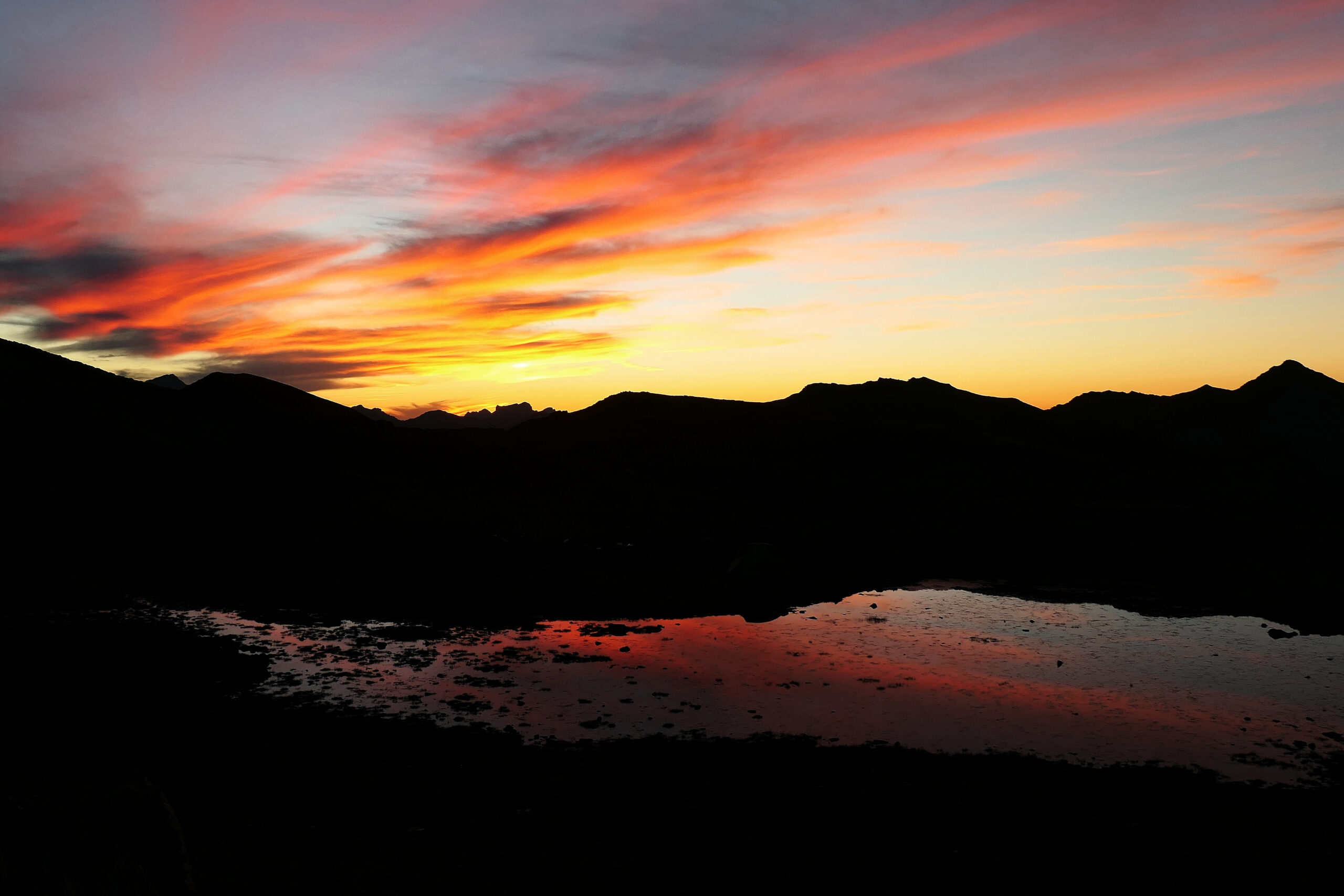 Coucher de soleil sur un lac et les montagnes dans les Pyrénées un soir de bivouac