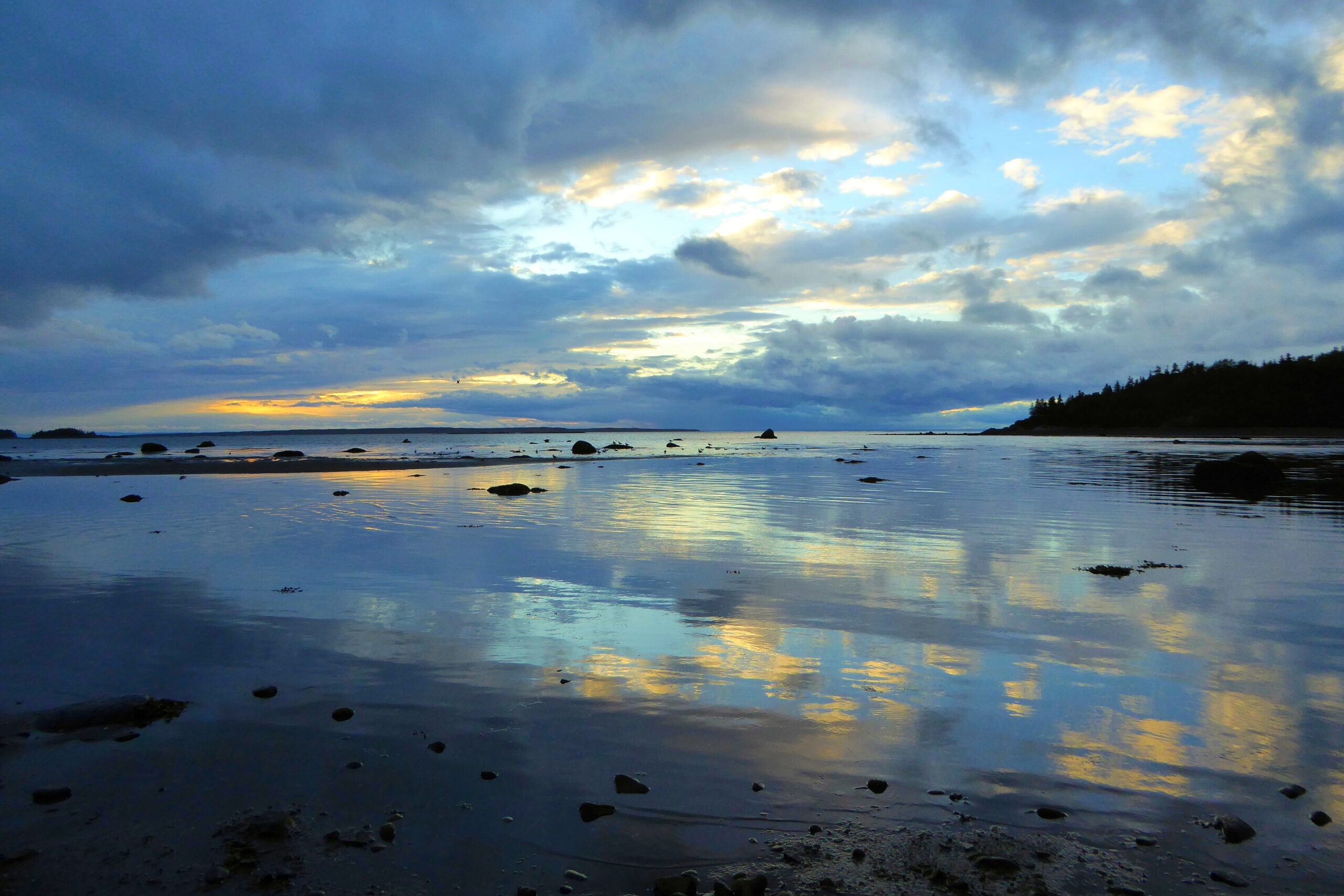 Reflets du ciel au coucher de soleil dans l'eau du parc du Bic, Québec