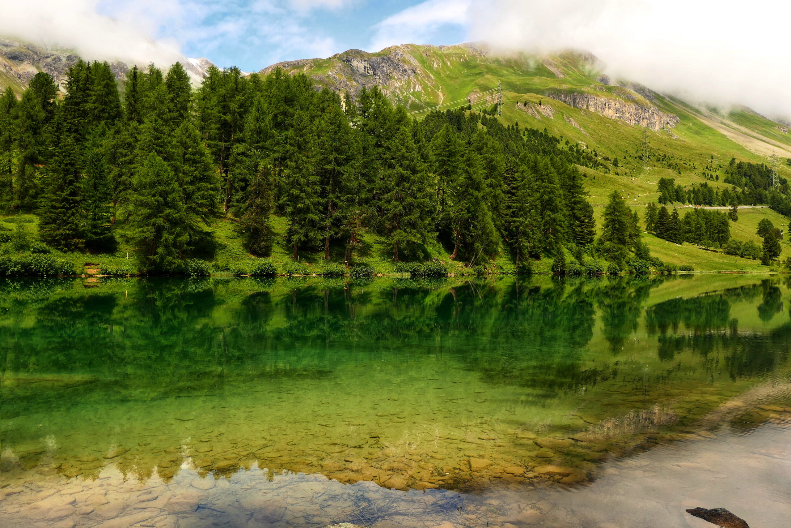 Le lac émeraude de Palpuogna en Suisse, avec ses eaux cristallines et ses montagnes en arrière-plan.