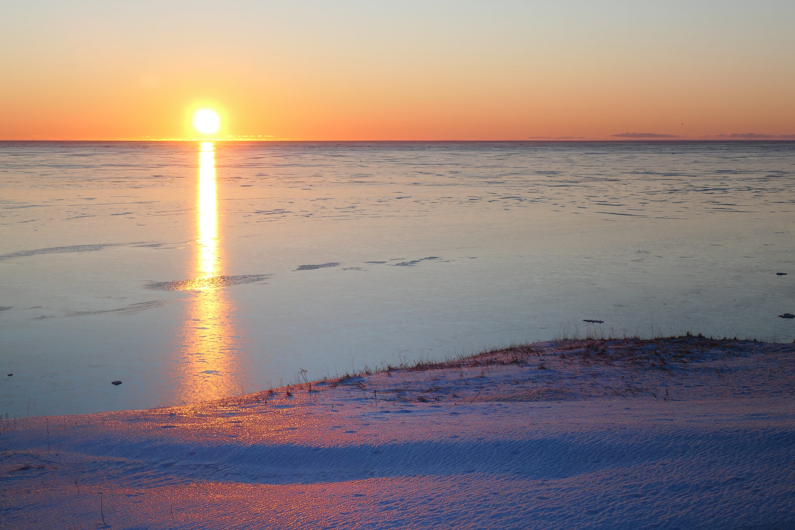 Lever de soleil hivernal sur une mer de glace aux îles de la Madeleine, Québec