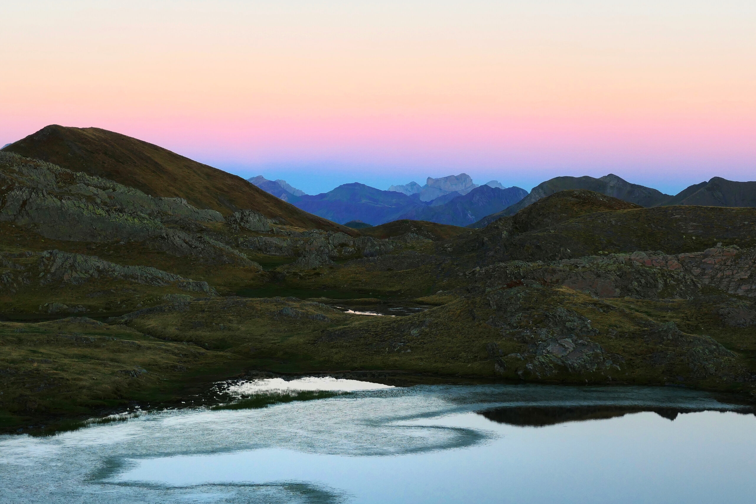 Lever de soleil sur un lac et les montagnes dans les Pyrénées après une nuit de bivouac