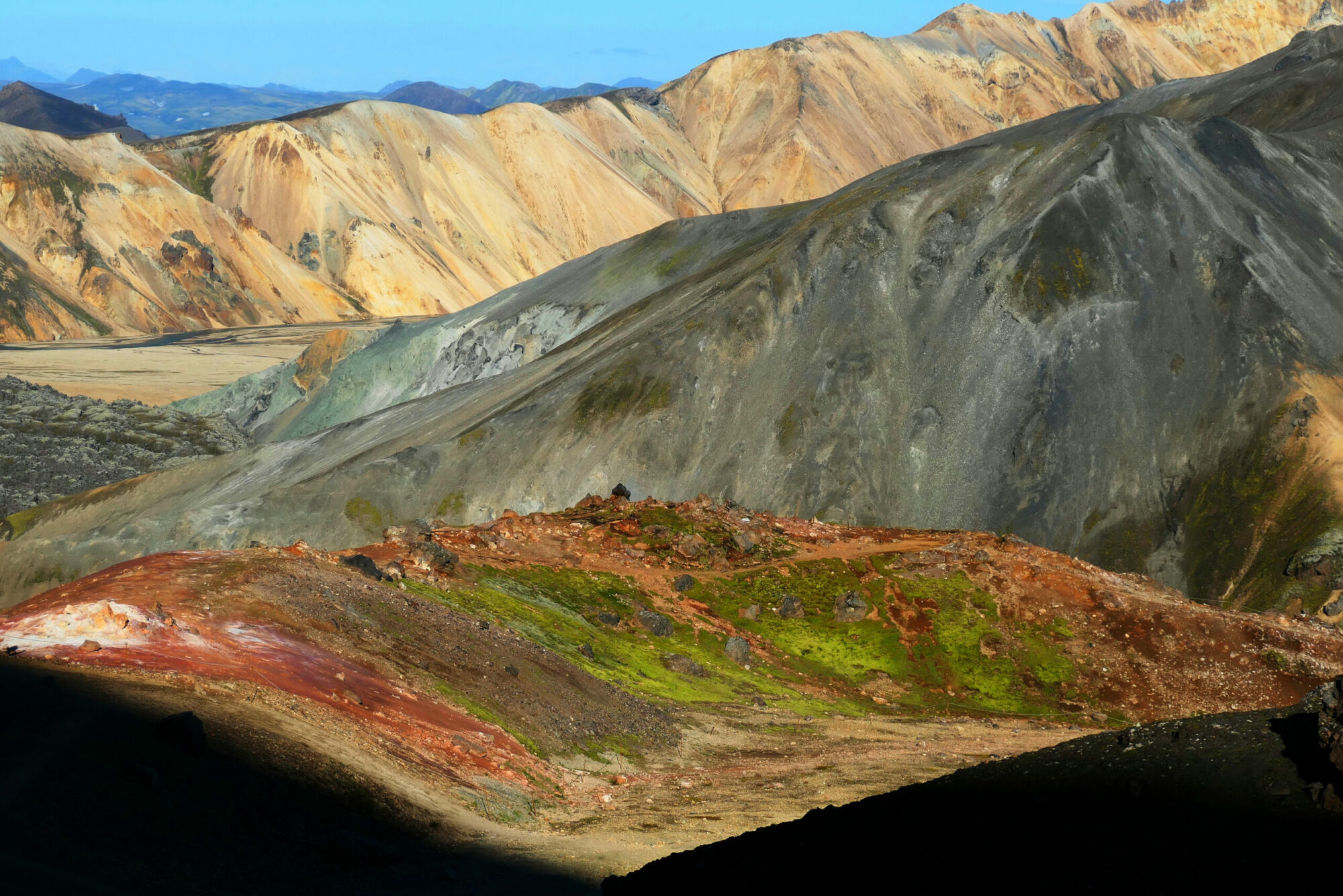 Gros plan des montagnes multicolores du Landmannalaugar en Islande, avec leurs teintes vives et leurs textures géologiques uniques.
