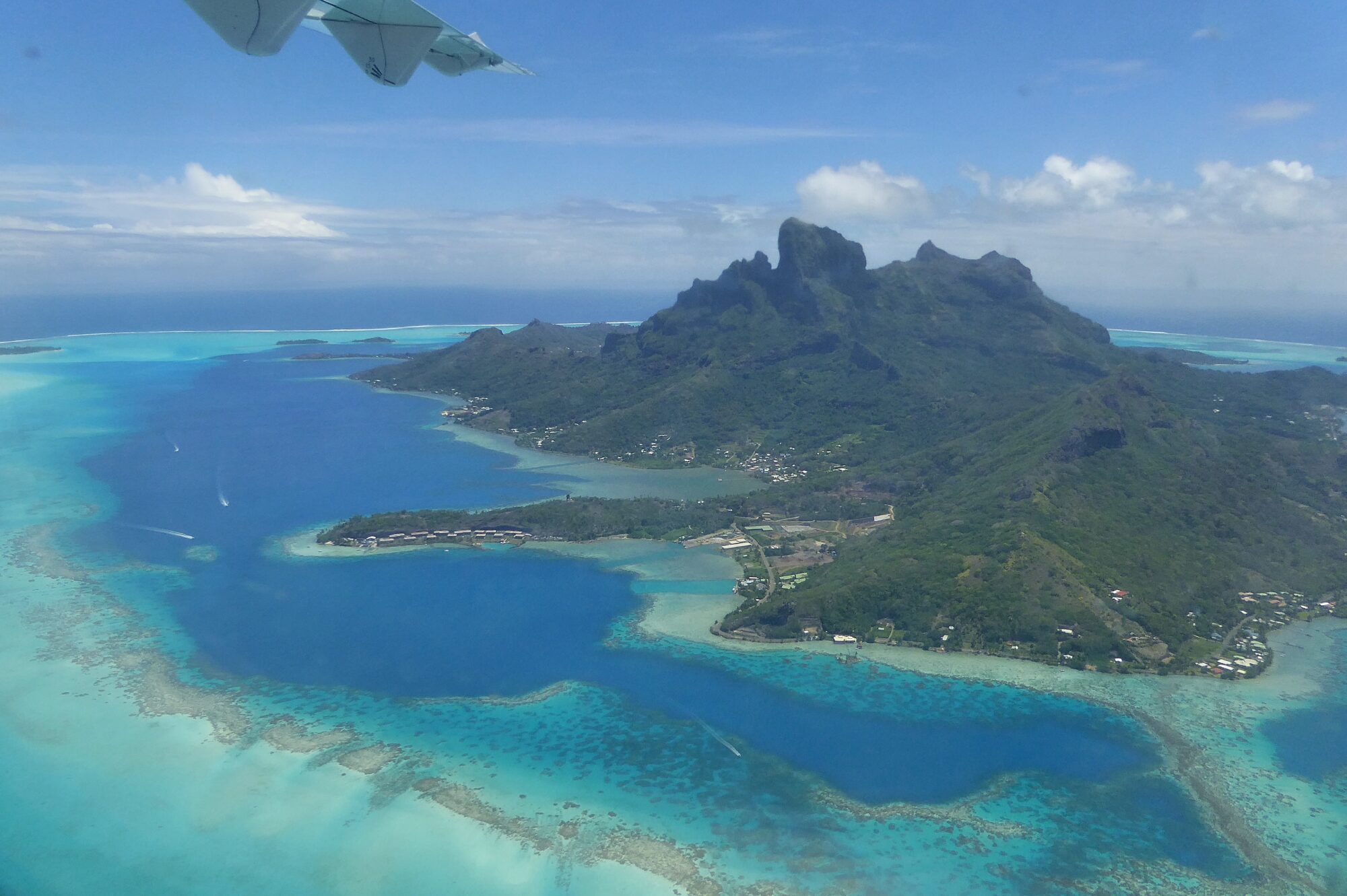 Vue aérienne de Bora Bora — mont Otemanu, lagon et village depuis l'avion, Polynésie française Vue aérienne de Bora Bora depuis l'avion montrant le mont Otemanu, le lagon aux nuances de bleu et le village de Vaitape, Polynésie française