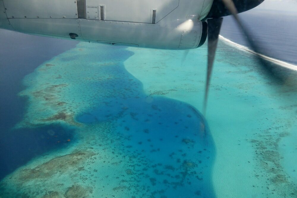 Vue depuis l'avion sur le lagon de Bora Bora et ses récifs coralliens aux incroyables nuances de bleu turquoise et azur, Polynésie française