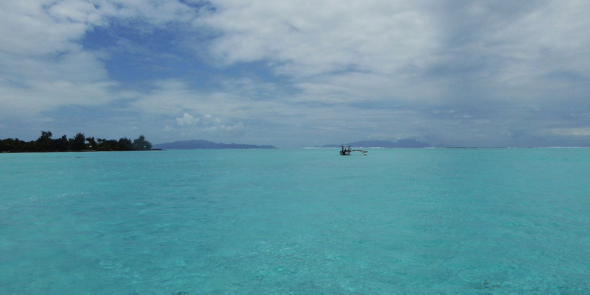 Lagon turquoise de Bora Bora avec bateau à balancier traditionnel — Polynésie française Le lagon de Bora Bora avec un bateau à balancier traditionnel polynésien.