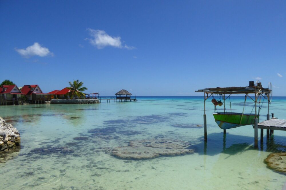 Snack en bord de lagon turquoise avec bungalows colorés, Fakarava Polynésie française