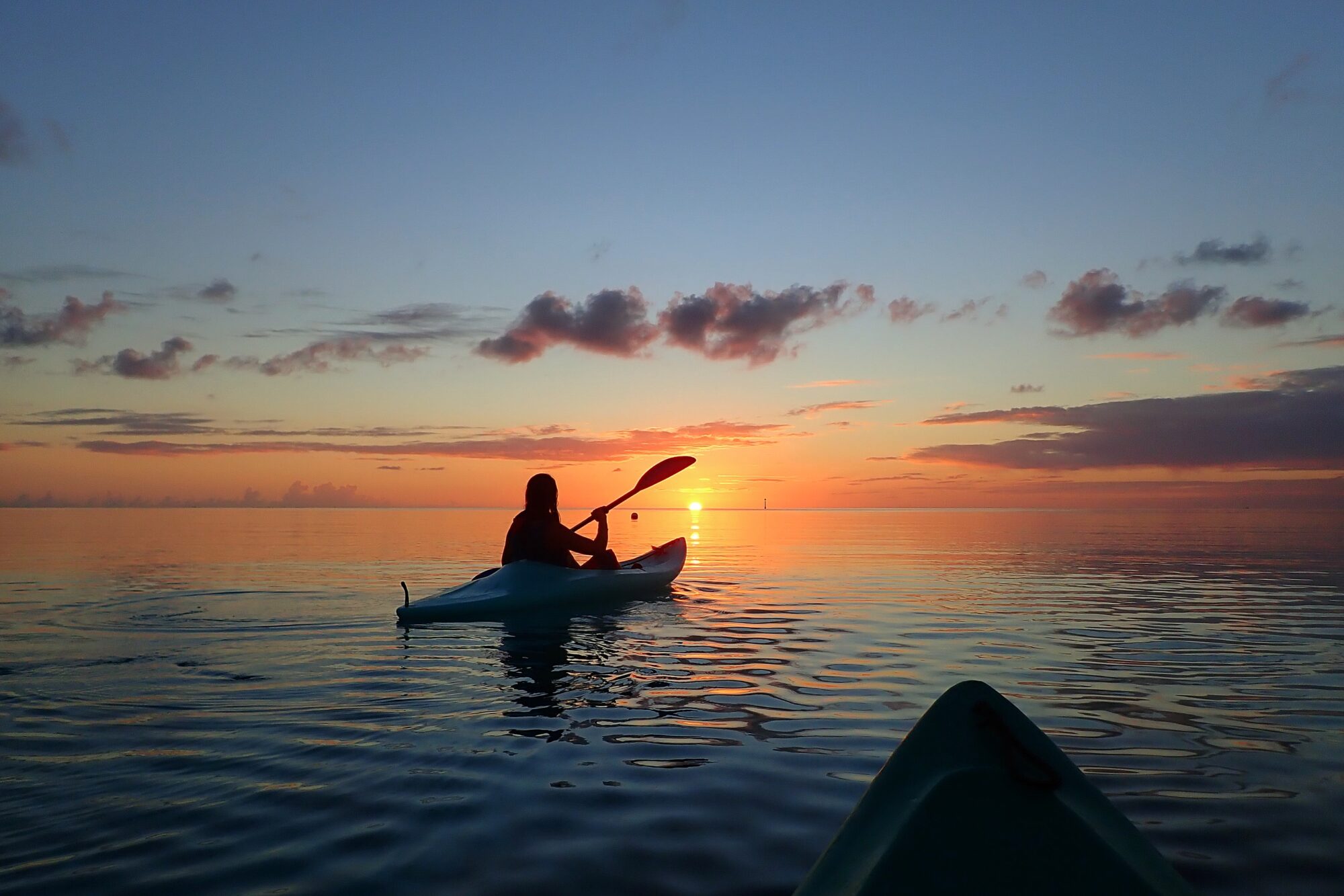 Silhouette en canoë au coucher de soleil sur le lagon, Fakarava Polynésie française