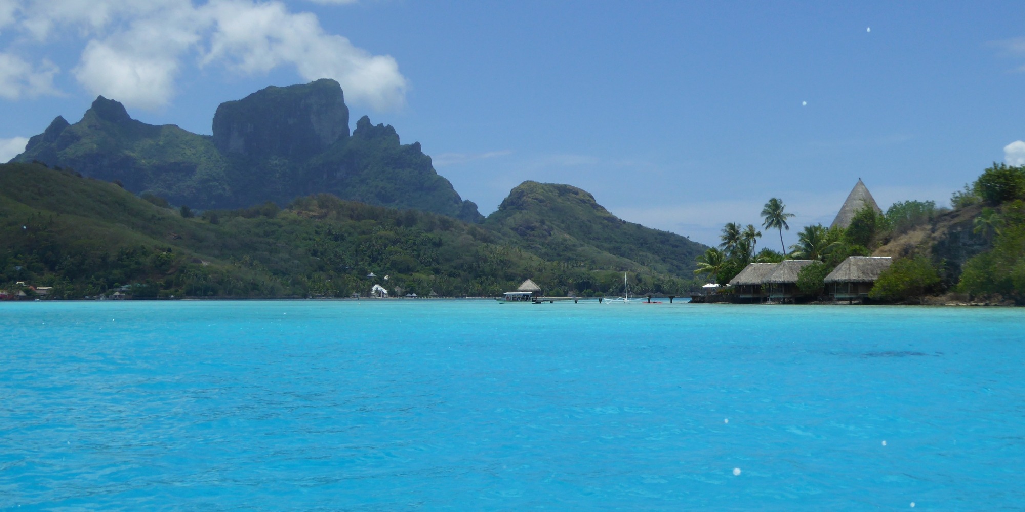 Mont Otemanu et bungalows sur pilotis sur le lagon turquoise de Bora Bora — Polynésie française Mont Otemanu dominant le lagon turquoise de Bora Bora avec des bungalows sur pilotis sur les motus, Polynésie française