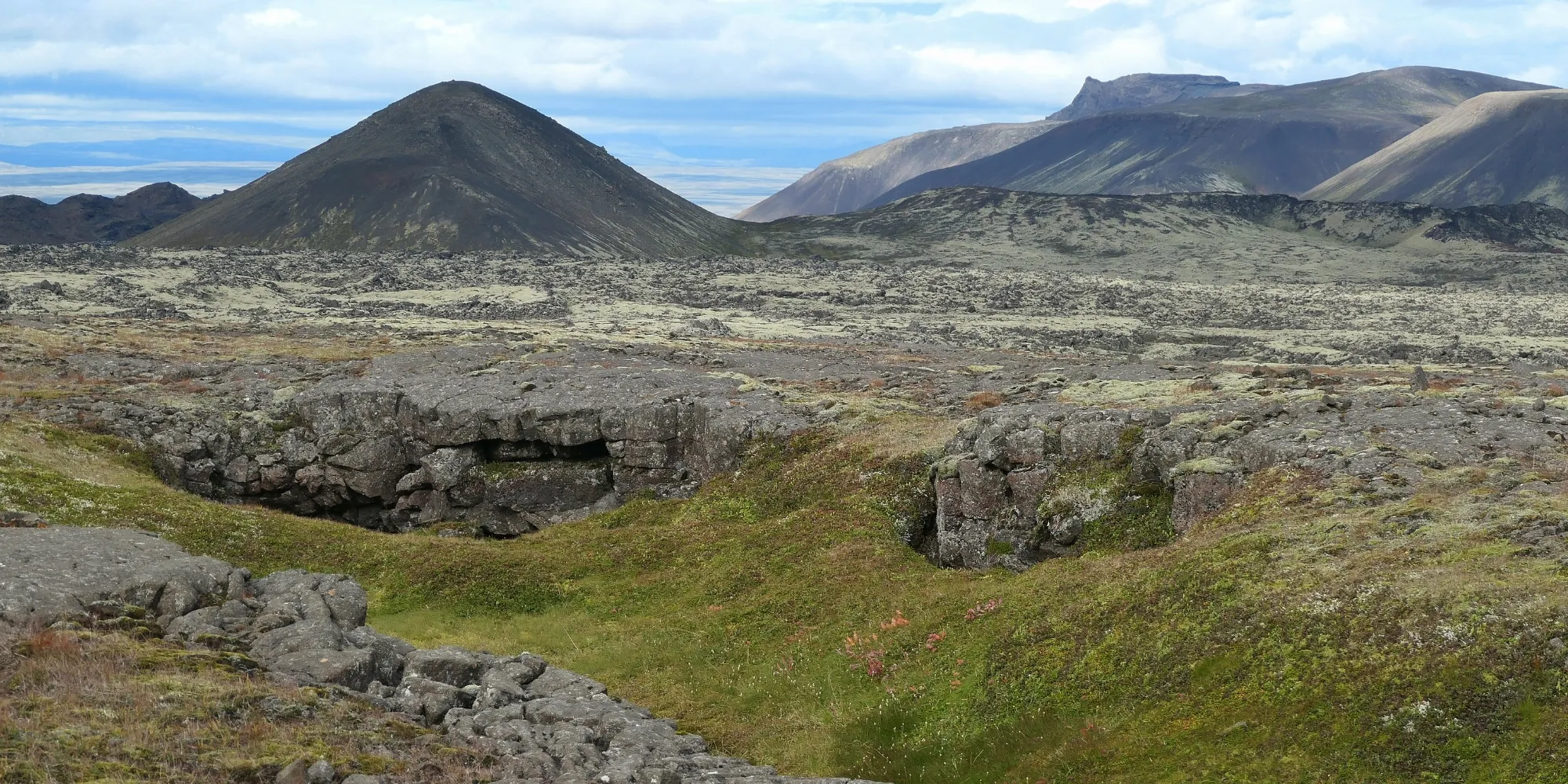 Faille de lave dans les hautes terres d'Islande Faille lave collines mousse hautes terres Islande